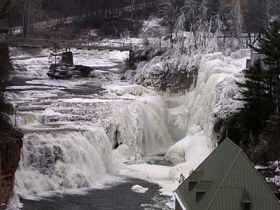 [A multi-level waterfall with significant portions frozen into thick icicles.]